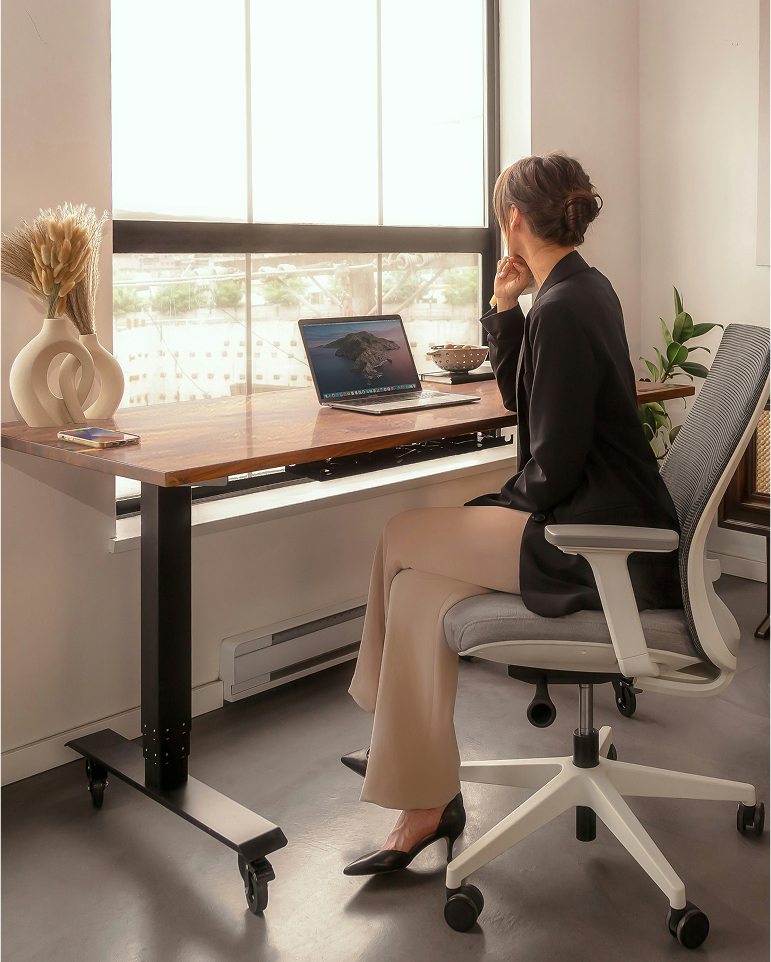 Professional seated at an office desk by a large window